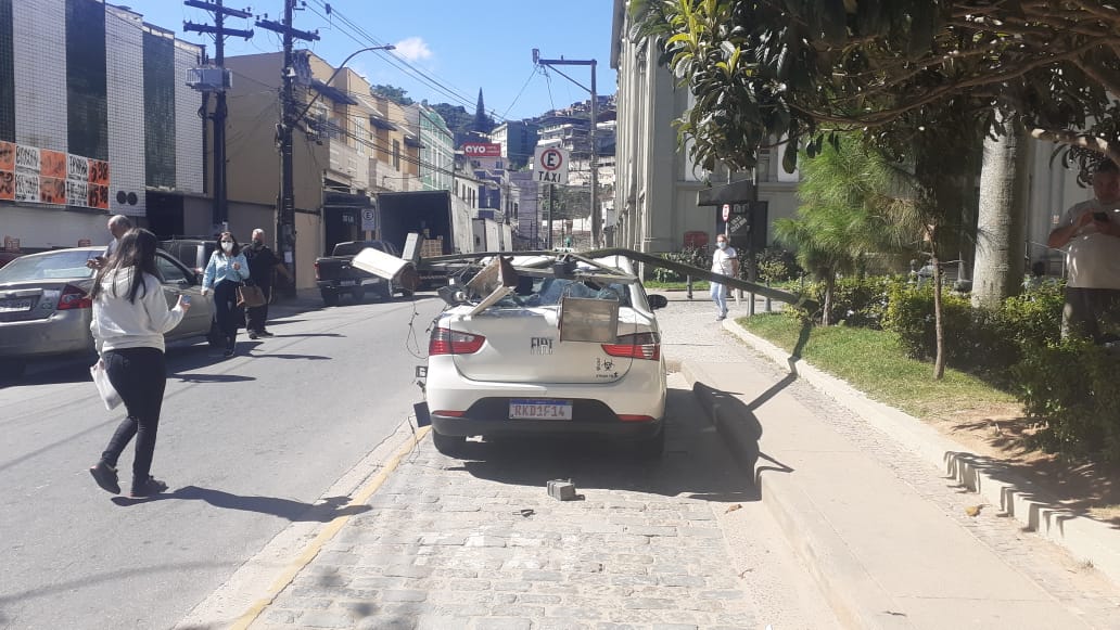 Susto! Poste cai e atinge táxi estacionado na Praça da Inconfidência. Motorista não ficou ferido