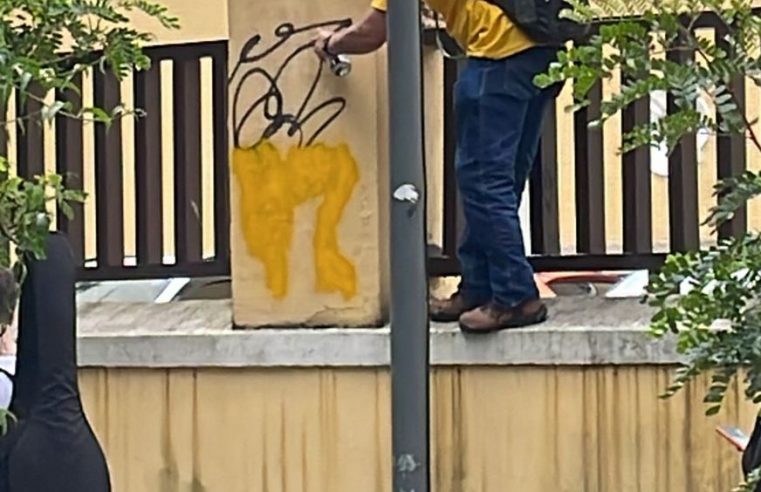 Homem tenta cobrir pichações no muro do Colégio Estadual Dom Pedro II (Cenip)