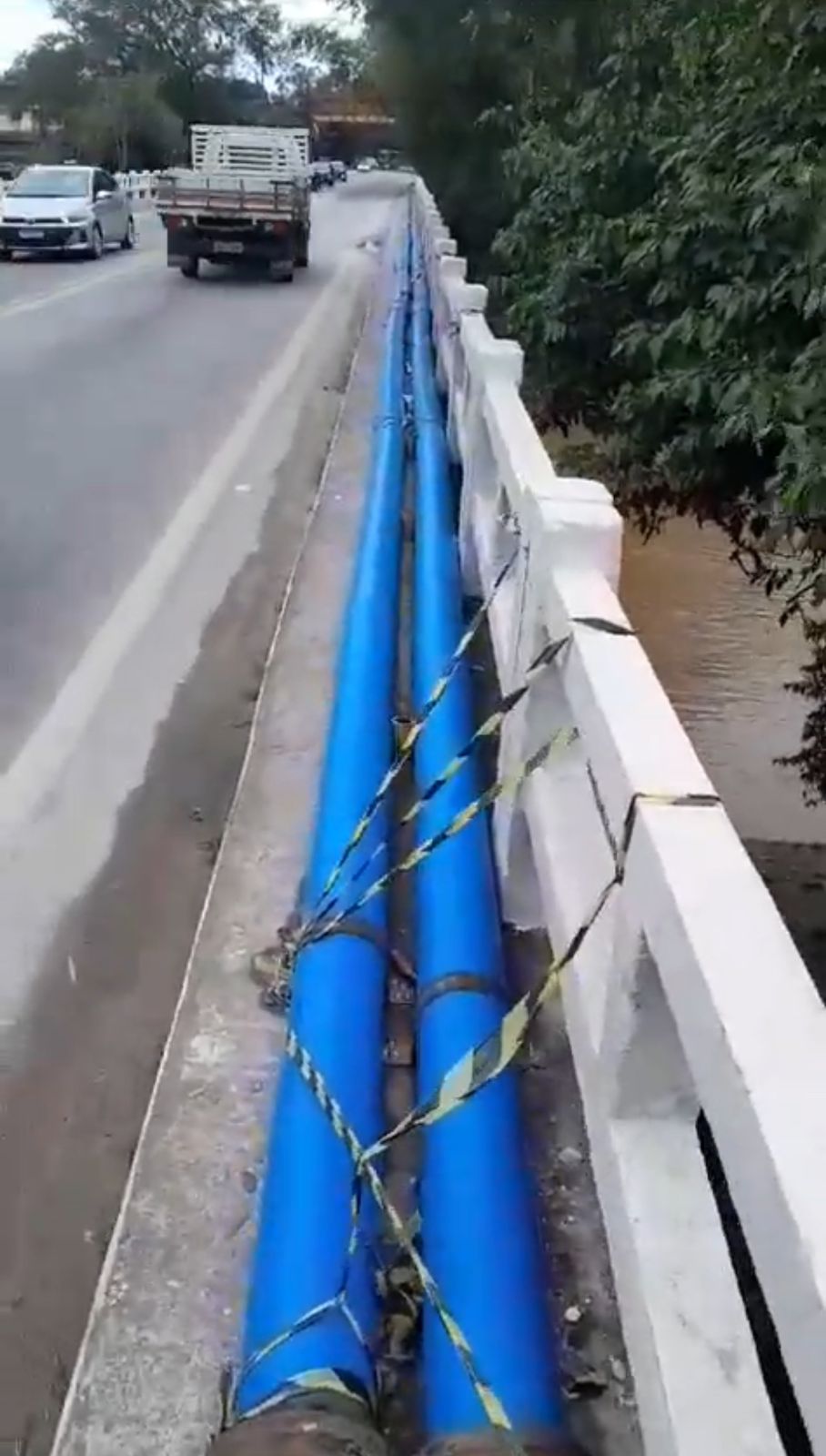 Serviço de Águas e Esgotos de Angra dos Reis instala tubos sobre passarela de ponte
