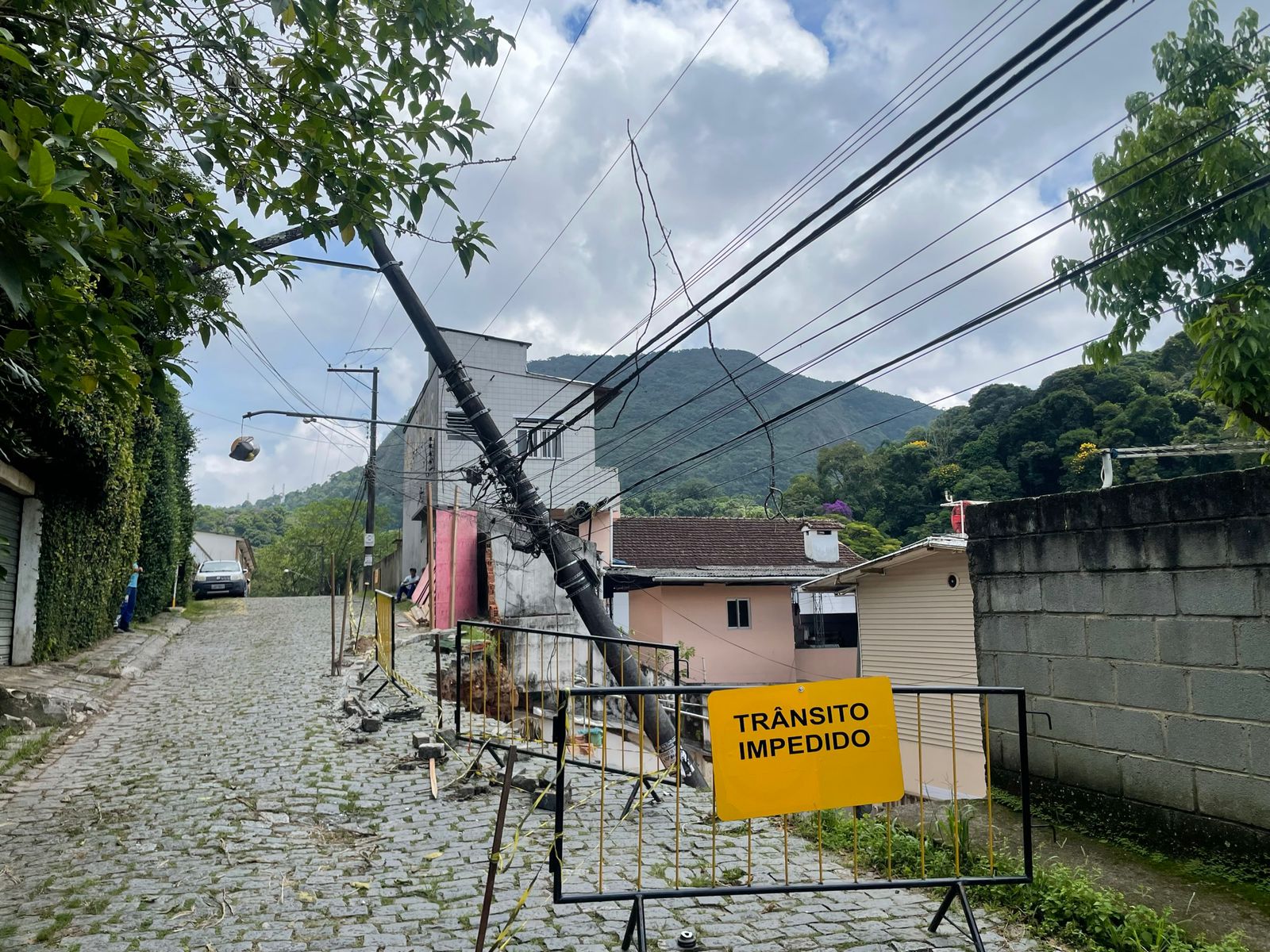 Trecho da Rua Vereador Décio Nicolay cede e atinge casa no Quitandinha: quase uma semana após incidente, poste segue pendurado