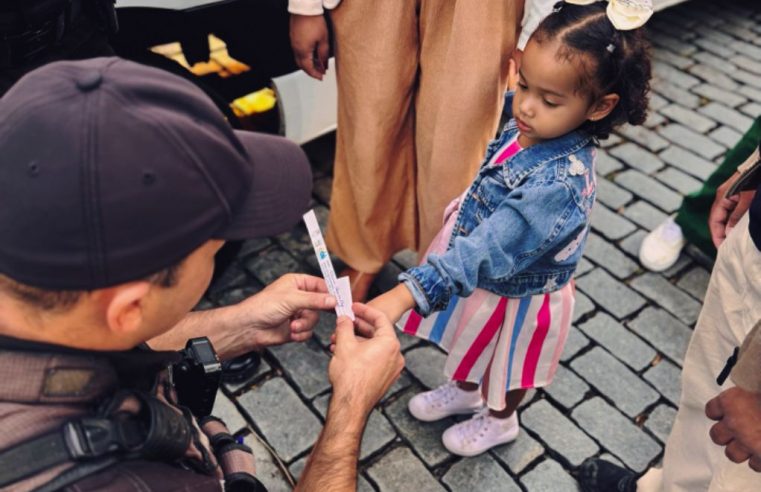 Equipes do 26° BPM distribuem pulseiras de identificação para crianças durante a Bauenrfest